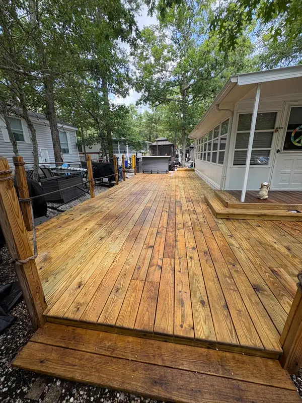 The same wood deck restored to clean natural wood after pressure washing